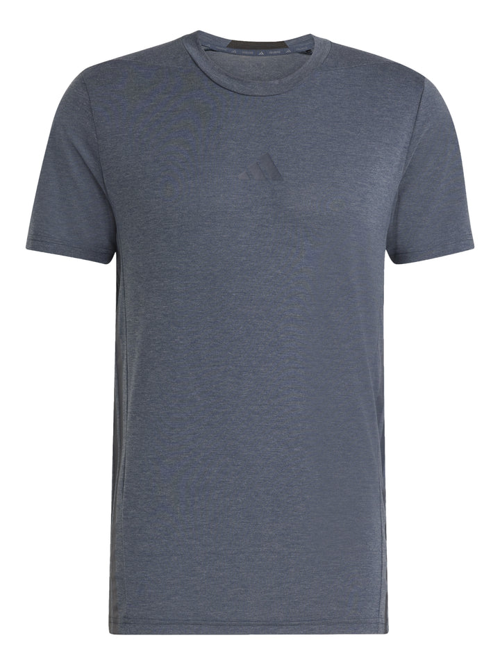 Hombre vistiendo una camiseta deportiva Adidas de color gris con cuello redondo y manga corta.