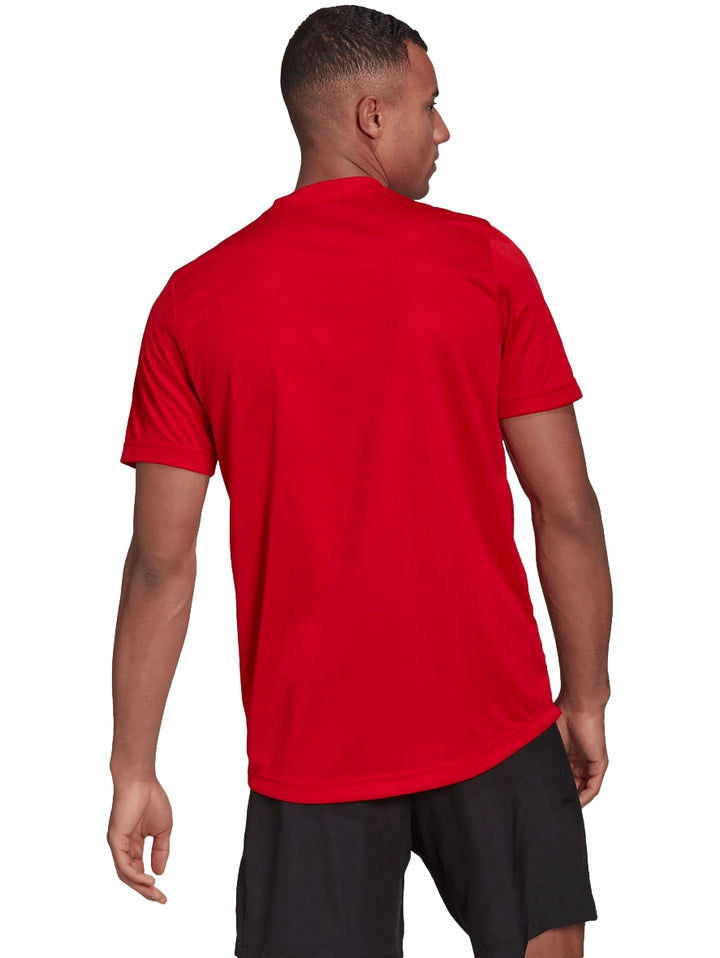 Hombre vistiendo una playera deportiva Adidas de color rojo con logo blanco en el pecho.