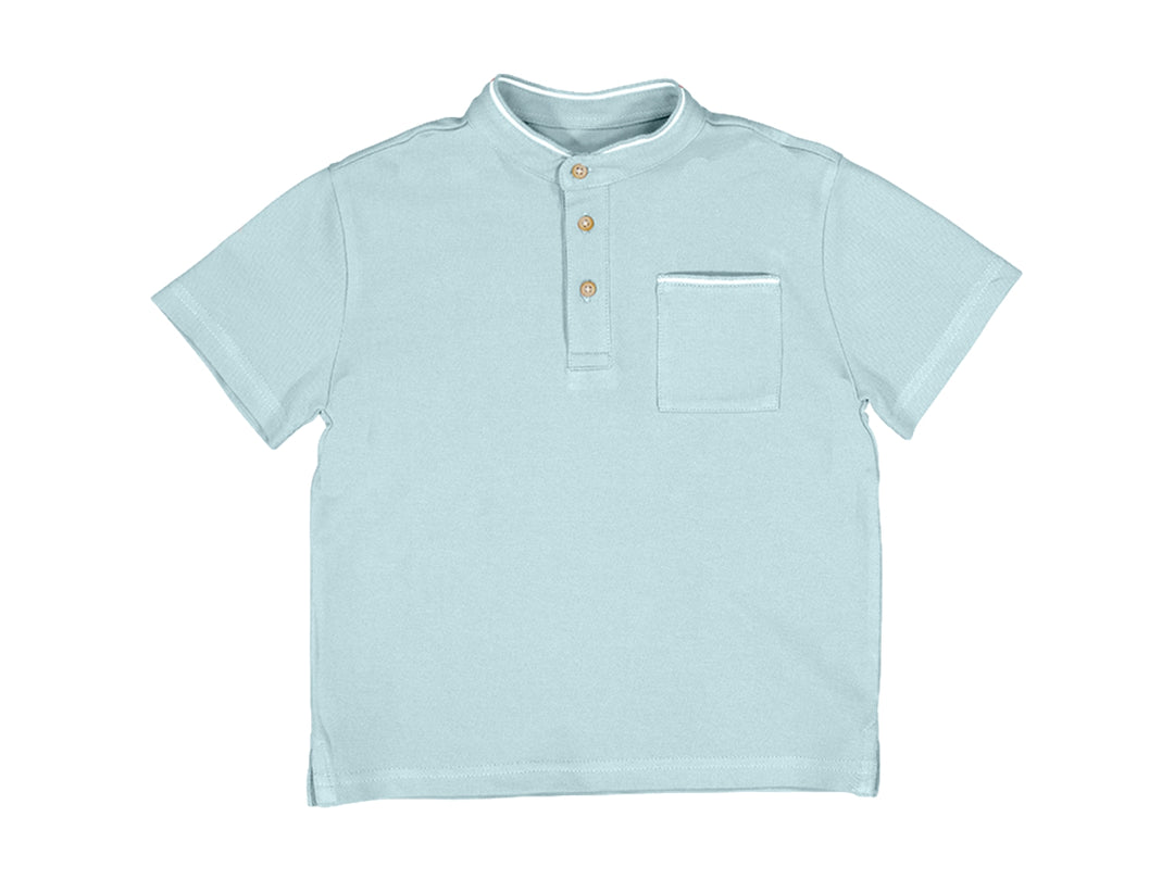 Polo color perla para niño con cuello mao, botones frontales y bolsillo en el pecho.