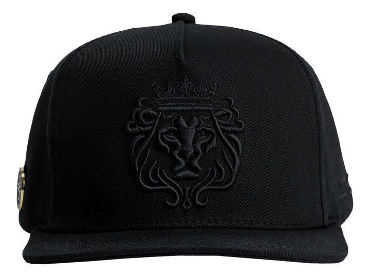 Gorra JC HATS color negro con bordado frontal en relieve de un león con corona.
