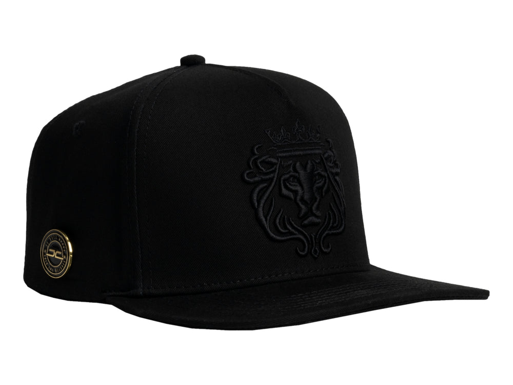 Gorra JC HATS color negro con bordado frontal en relieve de un león con corona.