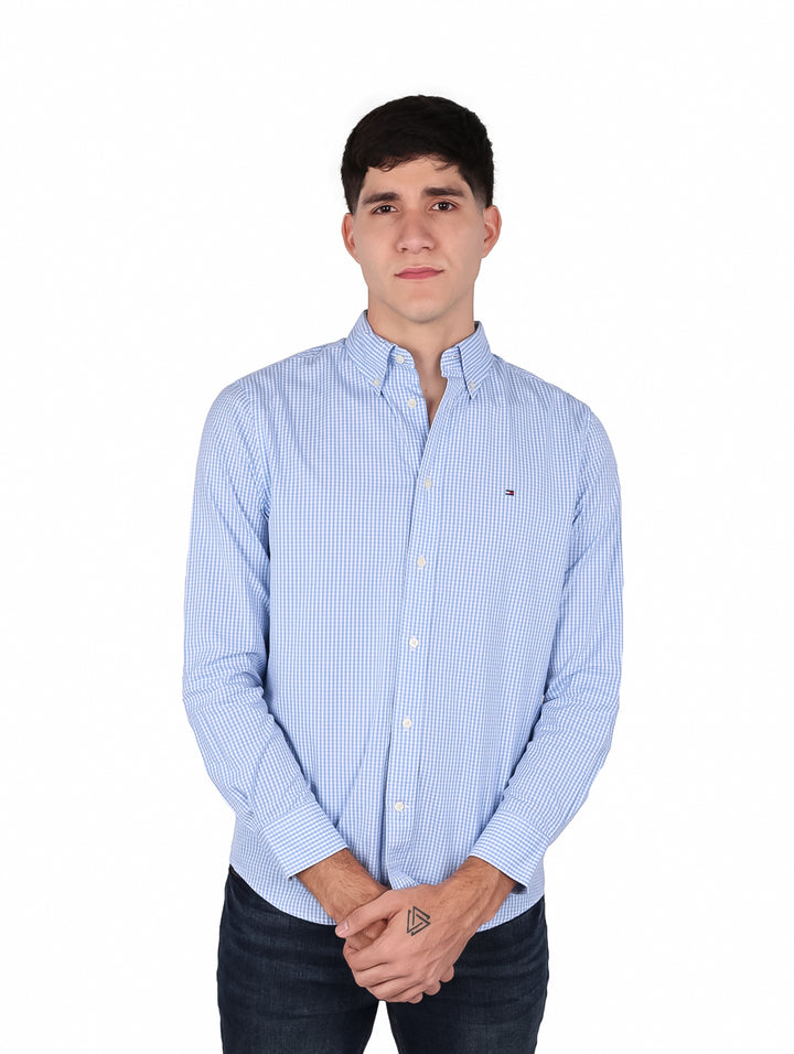 Hombre vistiendo camisa de manga larga con estampado de cuadros pequeños en color azul y blanco.