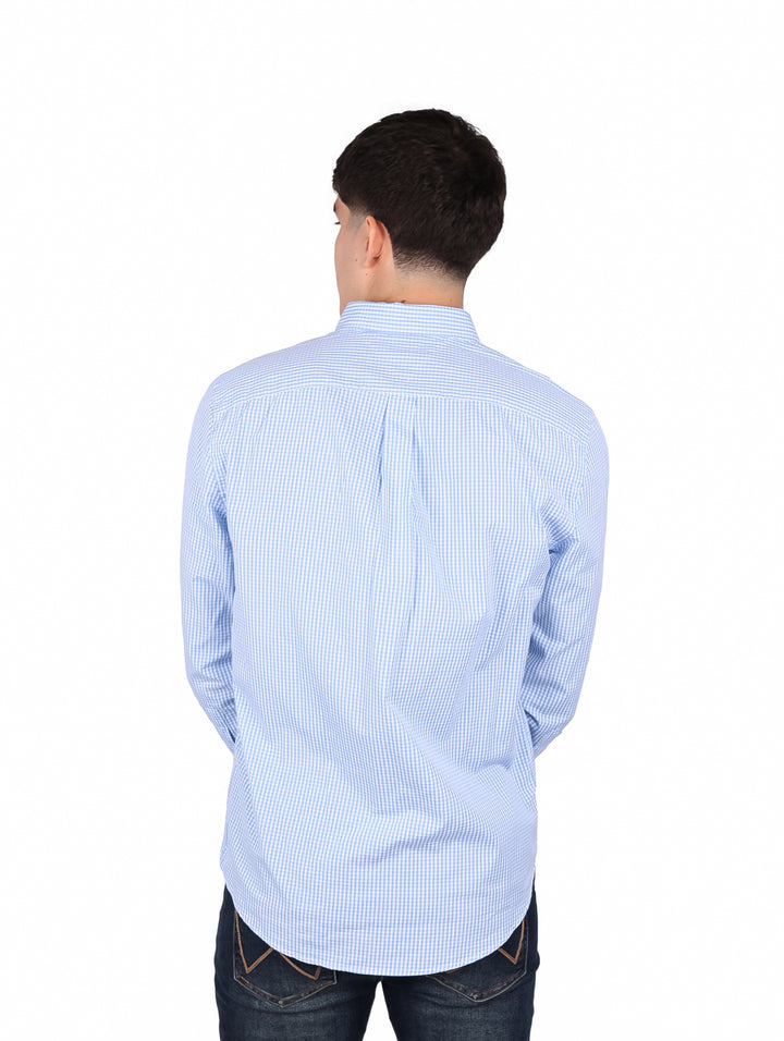 Hombre vistiendo camisa de manga larga con estampado de cuadros pequeños en color azul y blanco.