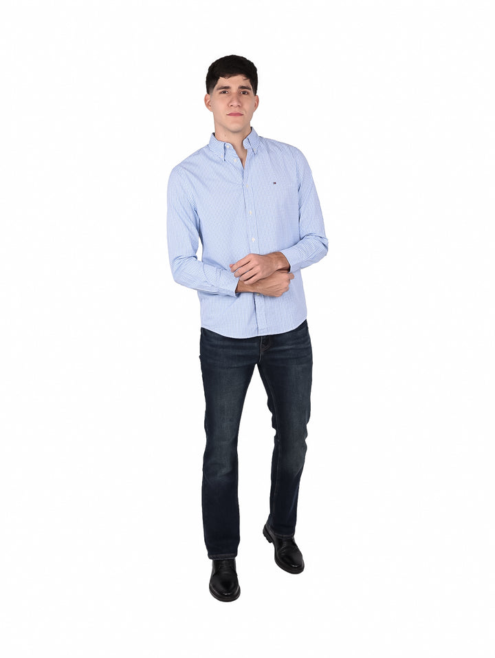Hombre vistiendo camisa de manga larga con estampado de cuadros pequeños en color azul y blanco.