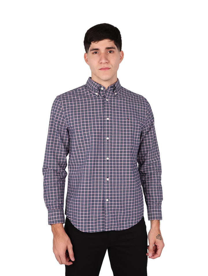 Hombre vistiendo camisa de manga larga con estampado de cuadros en tonos azul y blanco de Tommy Hilfiger.