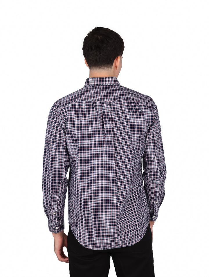 Hombre vistiendo camisa de manga larga con estampado de cuadros en tonos azul y blanco de Tommy Hilfiger.