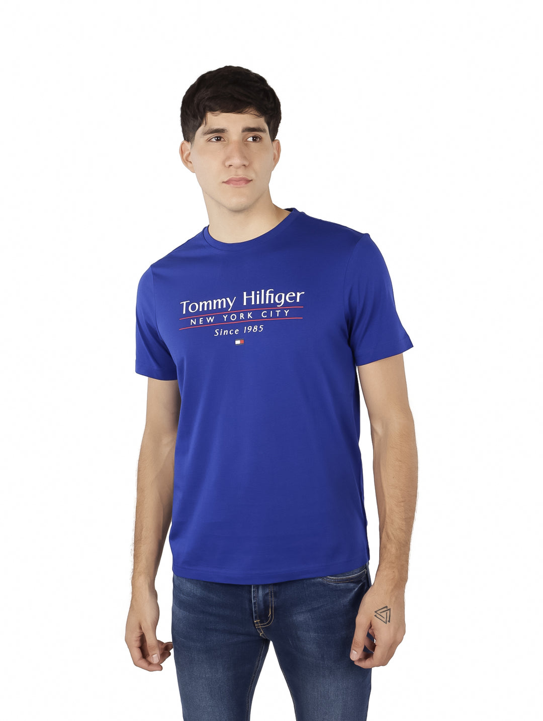 Hombre vistiendo una camiseta azul de manga corta con logotipo de Tommy Hilfiger en el pecho.