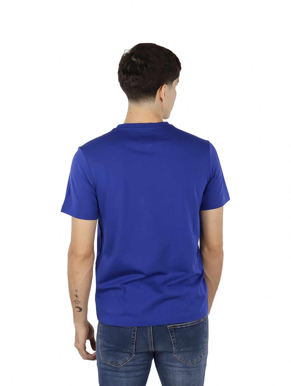 Hombre vistiendo una camiseta azul de manga corta con logotipo de Tommy Hilfiger en el pecho.