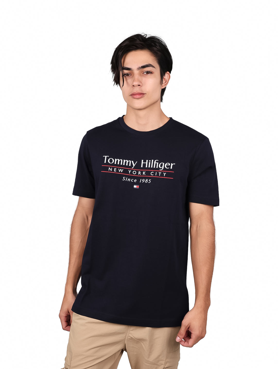 Hombre vistiendo camiseta azul marino de manga corta con texto de Tommy Hilfiger en el pecho.