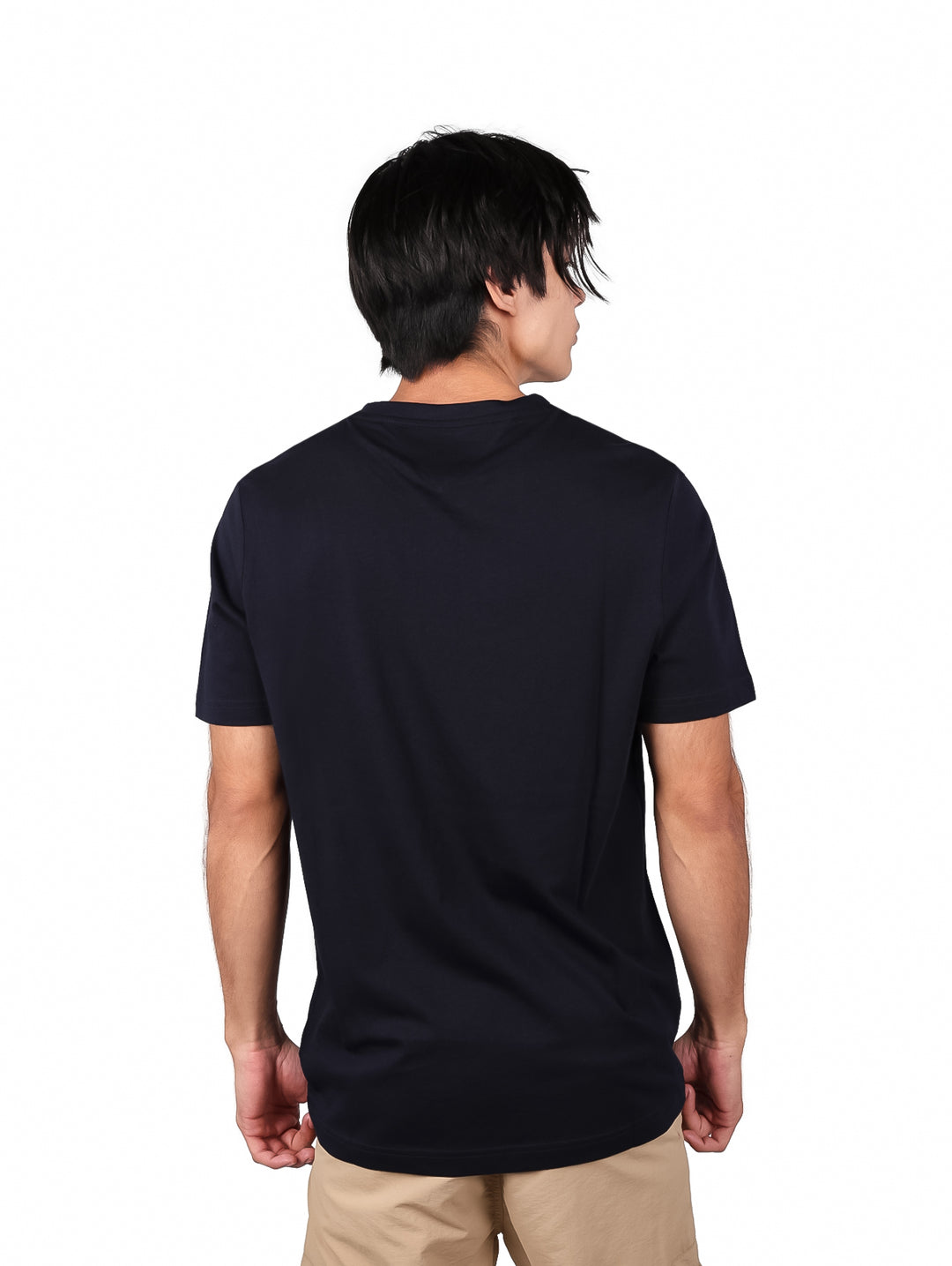 Hombre vistiendo camiseta azul marino de manga corta con texto de Tommy Hilfiger en el pecho.