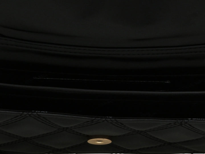 Bolsa negra Steve Madden con diseño acolchado y correa de cadena dorada.