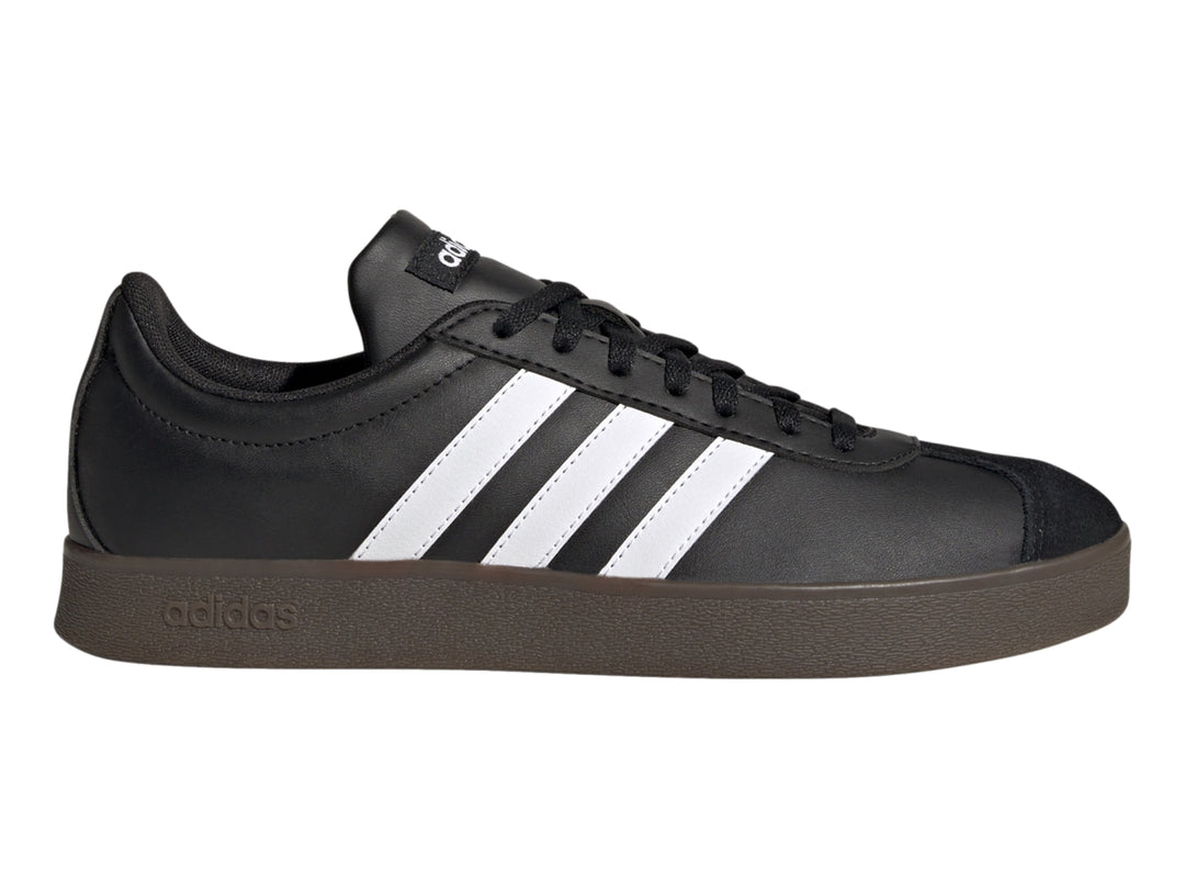 Tenis Adidas color negro con tres franjas blancas laterales y suela oscura.