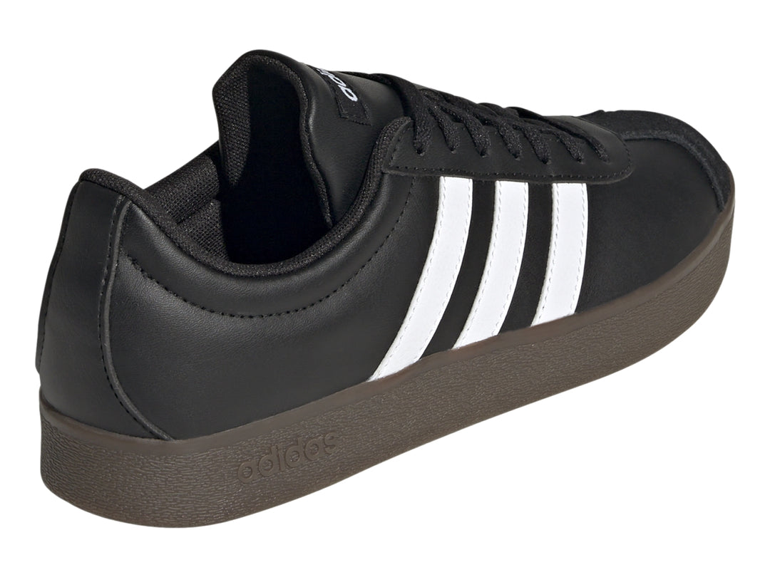 Tenis Adidas color negro con tres franjas blancas laterales y suela oscura.