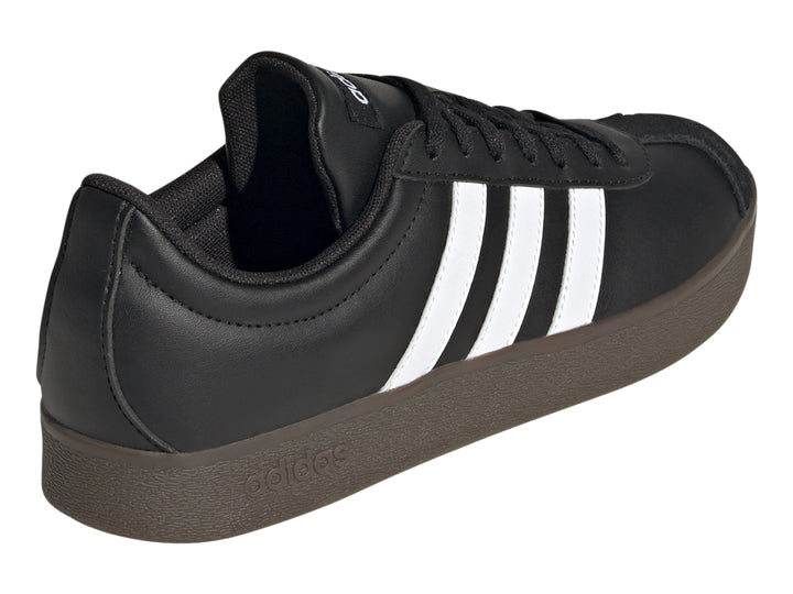 Tenis Adidas color negro con tres franjas blancas laterales y suela oscura.