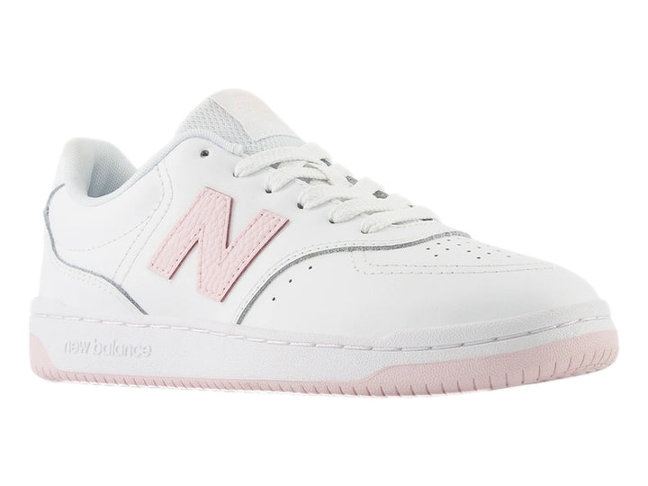 Tenis New Balance color blanco con logotipo y suela en color rosa.