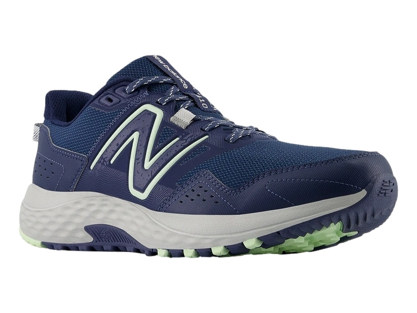Tenis New Balance MT 410 en color azul marino con detalles en verde menta y suela gris.