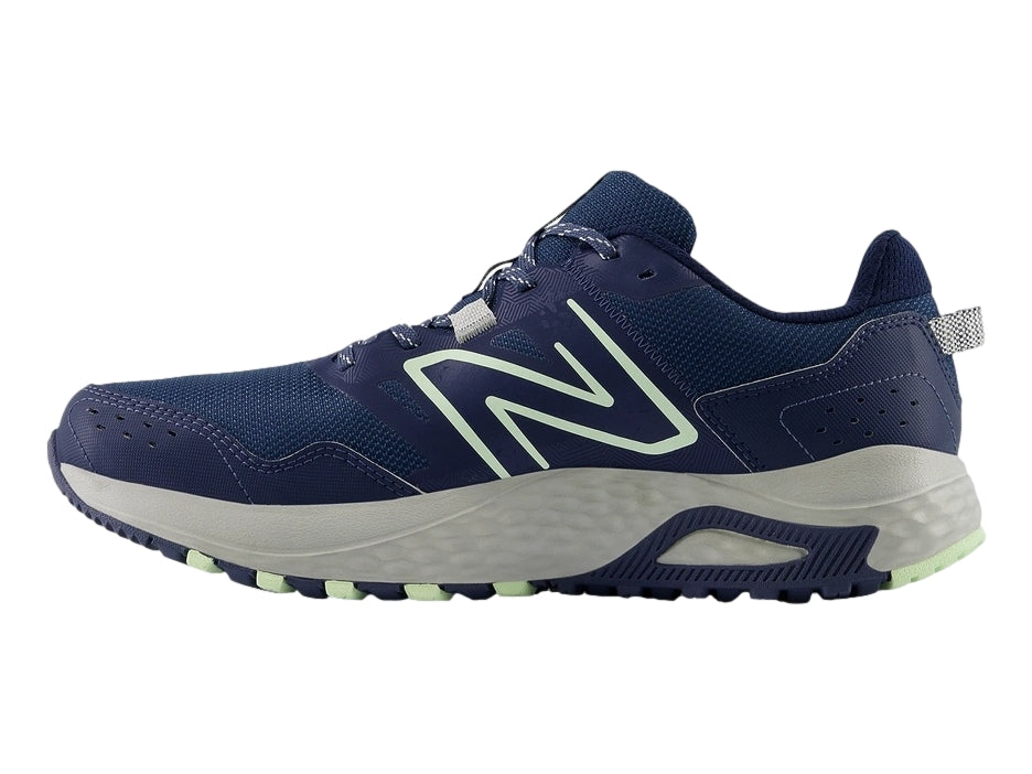 Tenis New Balance MT 410 en color azul marino con detalles en verde menta y suela gris.