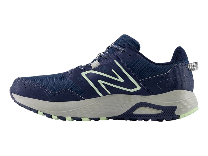 Tenis New Balance MT 410 en color azul marino con detalles en verde menta y suela gris.