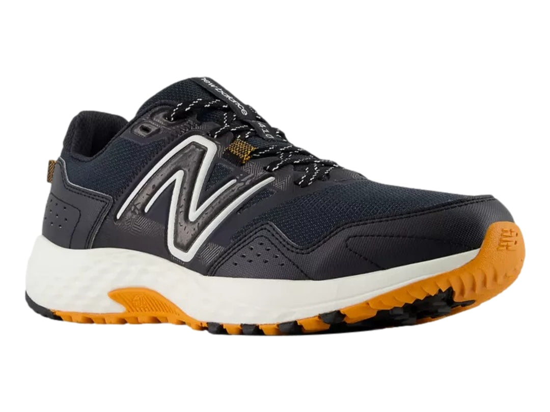 Tenis New Balance deportivos color negro con suela blanca y naranja.