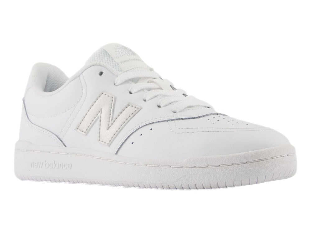 Tenis New Balance color blanco con logotipo en plata y suela blanca, vista lateral.