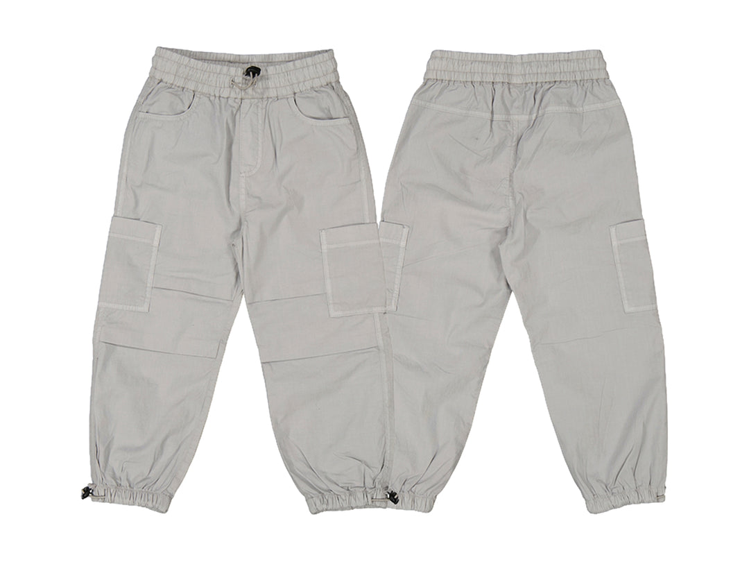 Pantalón gris estilo parachute para niño con cintura y tobillos elásticos y bolsillos laterales.