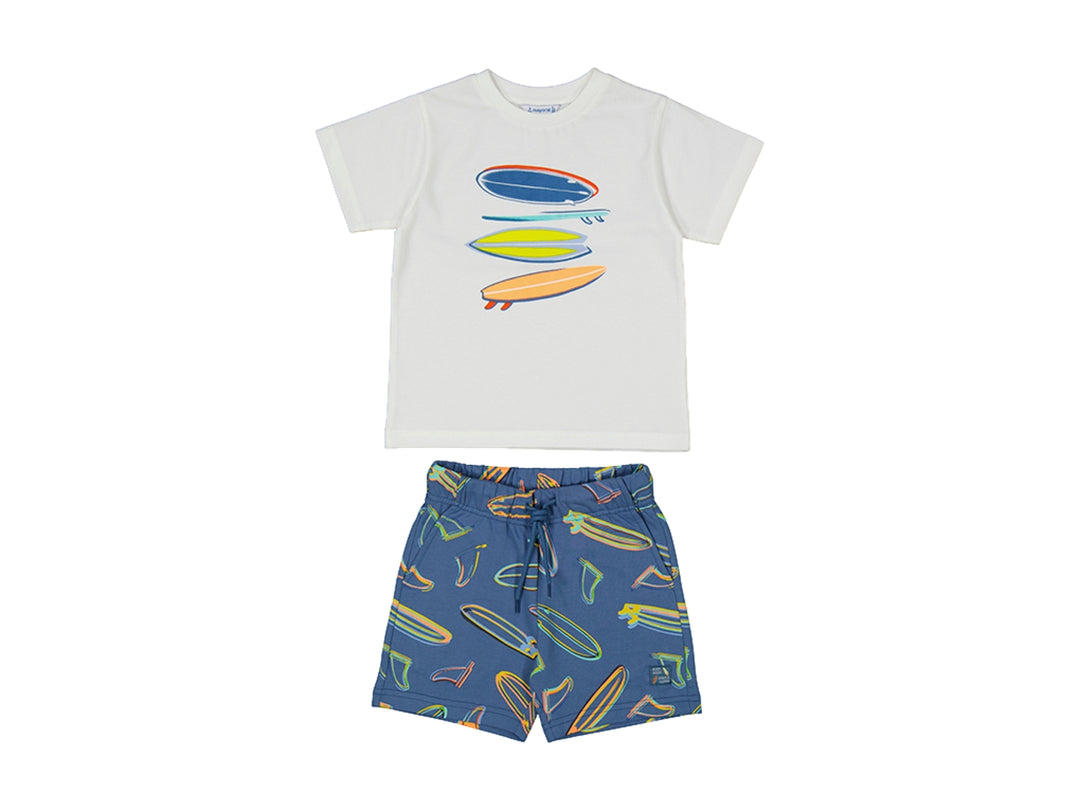 Conjunto de ropa infantil compuesto por camiseta blanca y shorts azules con estampados de tablas de surf.
