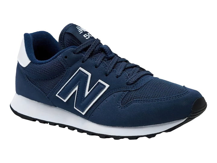 Tenis New Balance color azul marino con suela blanca y detalles en blanco.