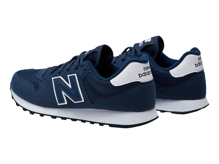 Tenis New Balance color azul marino con suela blanca y detalles en blanco.