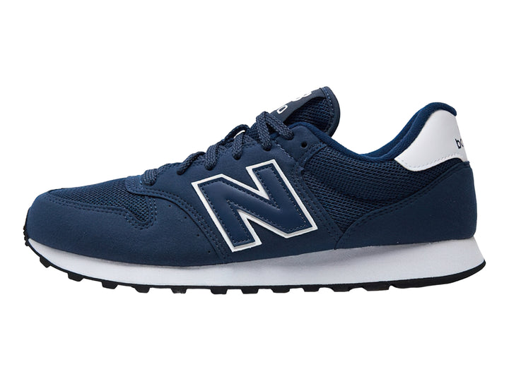 Tenis New Balance color azul marino con suela blanca y detalles en blanco.
