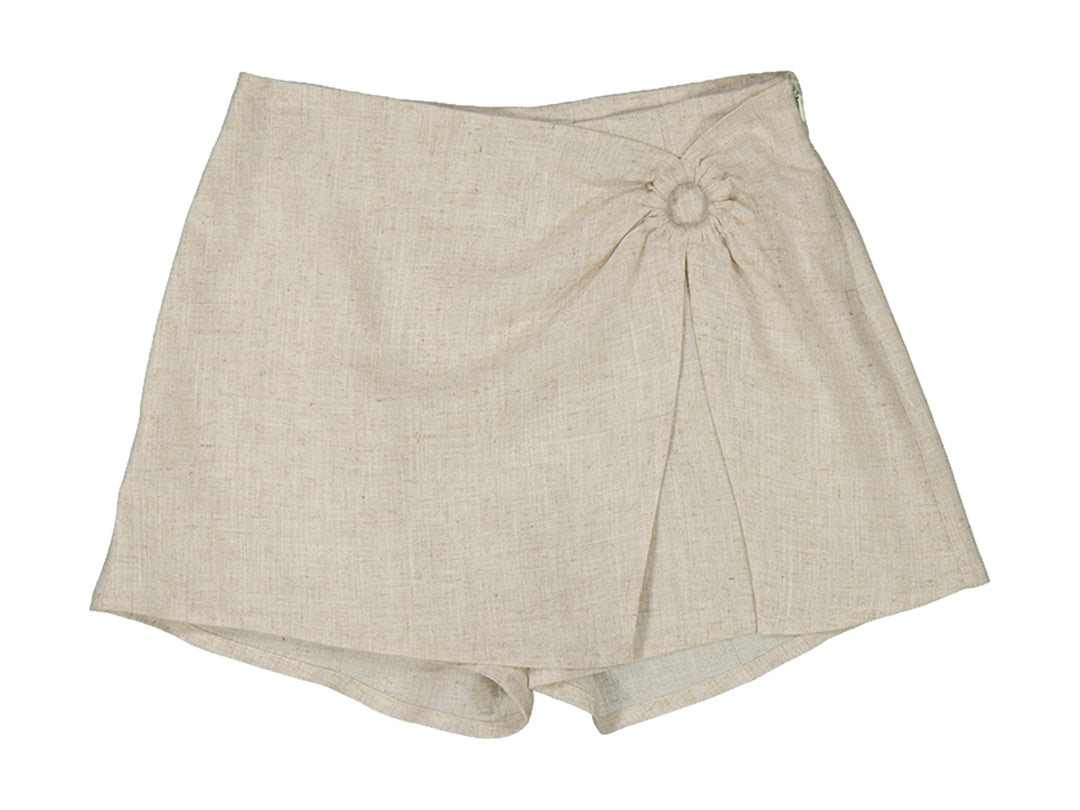 Falda pantalón color lino para niña con detalle de arandela frontal y diseño cruzado.