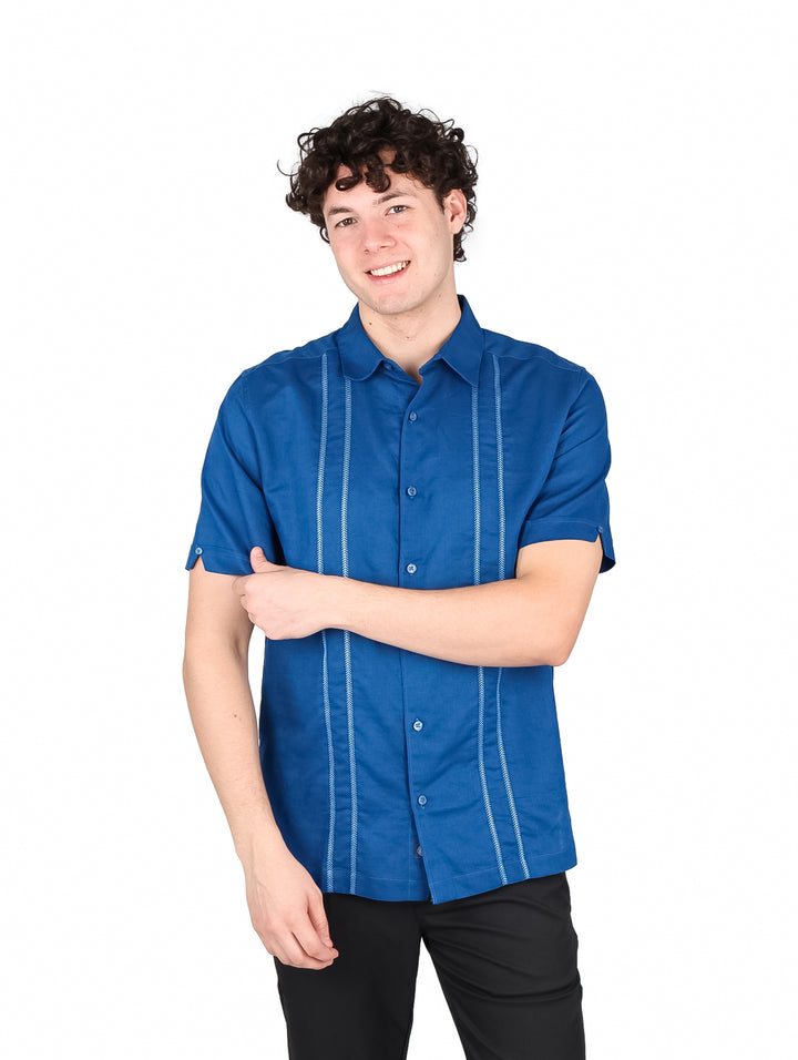 Hombre vistiendo camisa CubaVera color azul blueberry pancake de manga corta con detalles de costuras verticales.