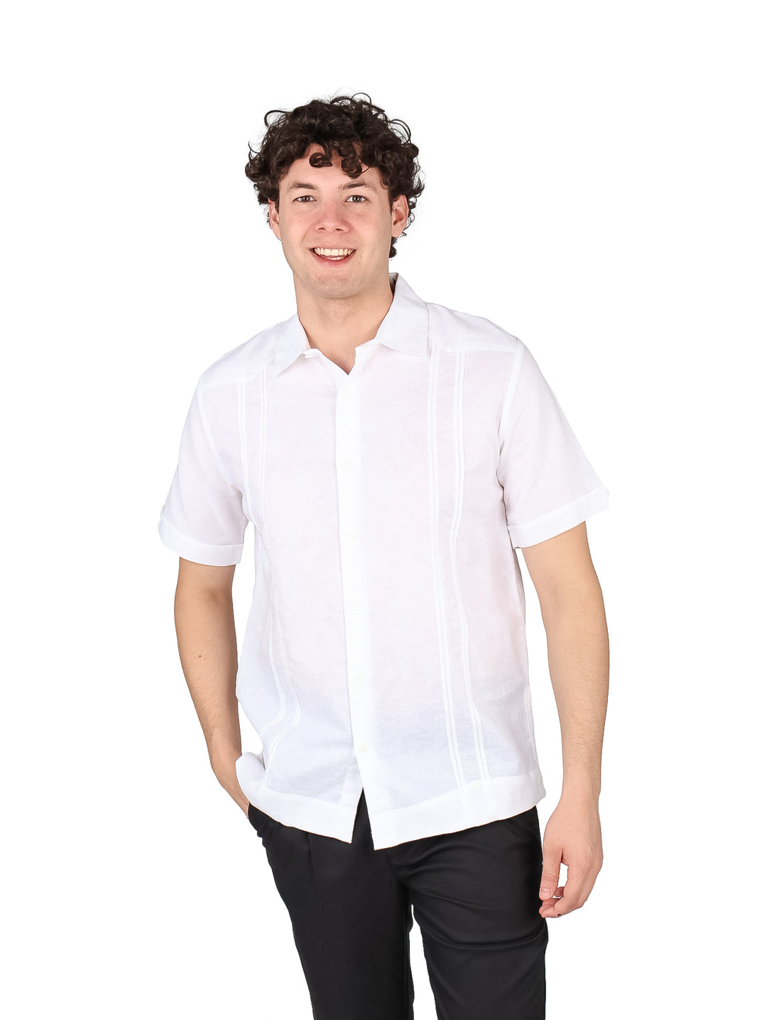 Hombre vistiendo una guayabera blanca de manga corta con detalles plisados.