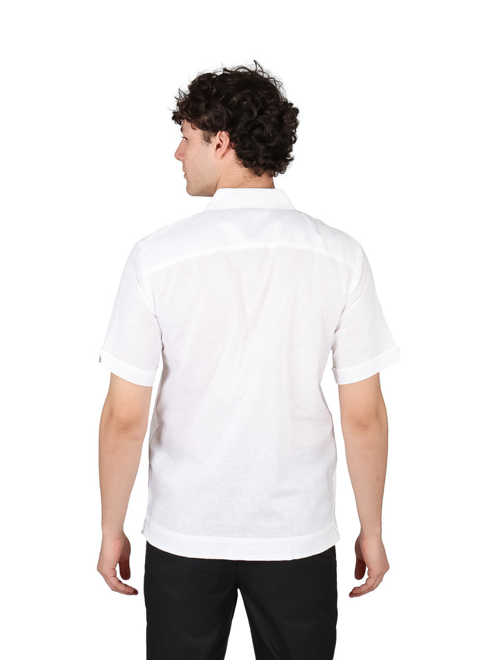 Hombre vistiendo una guayabera blanca de manga corta con detalles plisados.