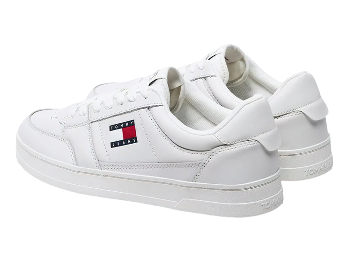 Tenis Tommy Hilfiger color blanco ecru con logo lateral y suela plana blanca.