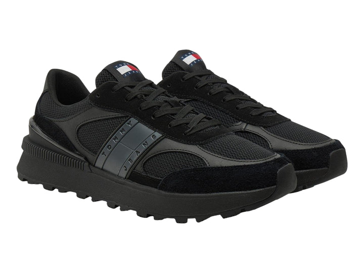 Tenis deportivos Tommy Hilfiger color negro con suela gruesa y detalles en malla y gamuza.