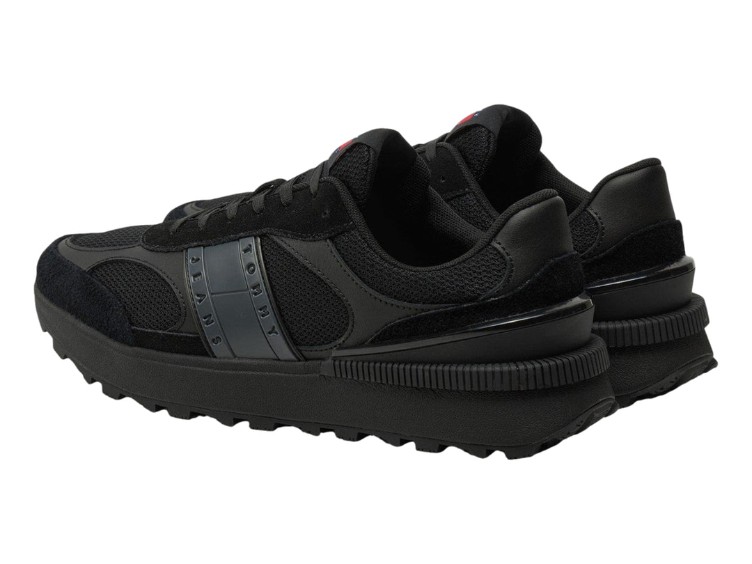 Tenis deportivos Tommy Hilfiger color negro con suela gruesa y detalles en malla y gamuza.