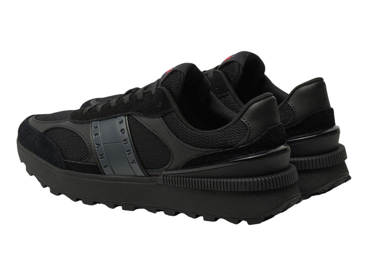 Tenis deportivos Tommy Hilfiger color negro con suela gruesa y detalles en malla y gamuza.