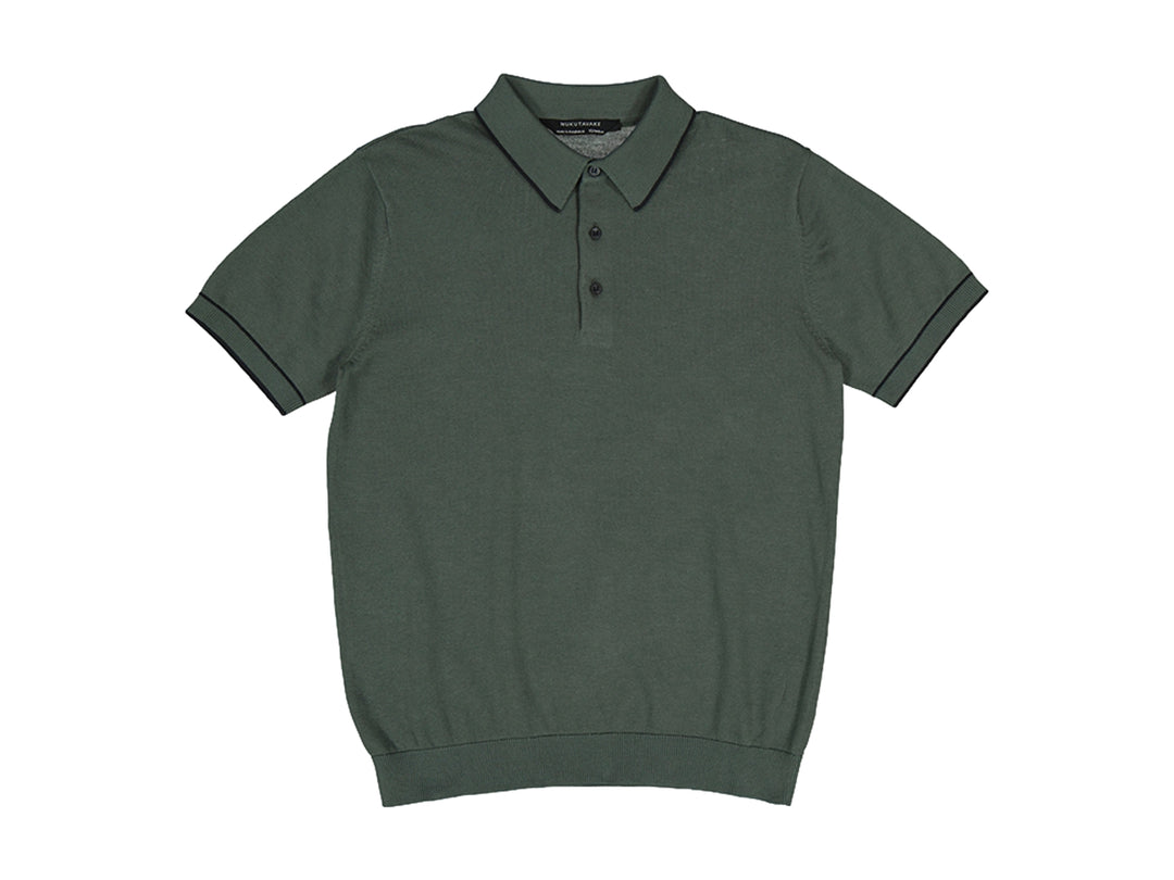 Camiseta polo de manga corta color verde eucalipto con detalles negros en el cuello y bordes de las mangas.