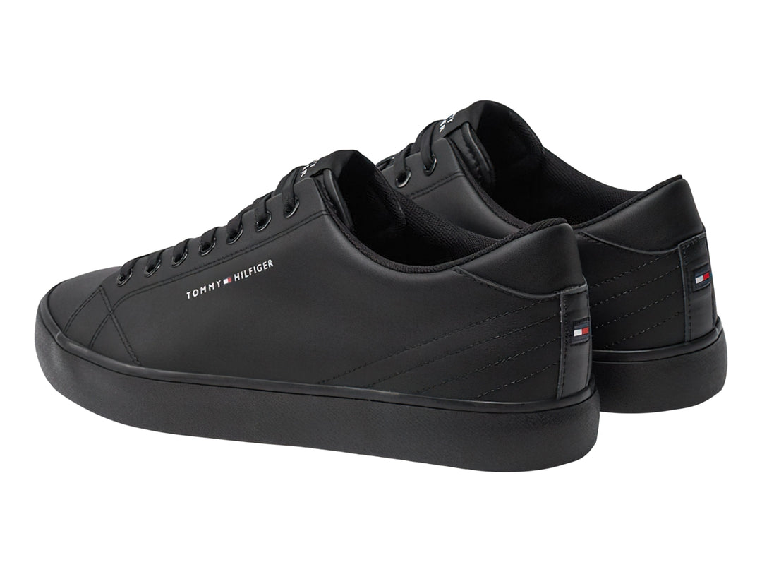 Tenis casuales Tommy Hilfiger de cuero color negro con suela vulcanizada y cordones negros.