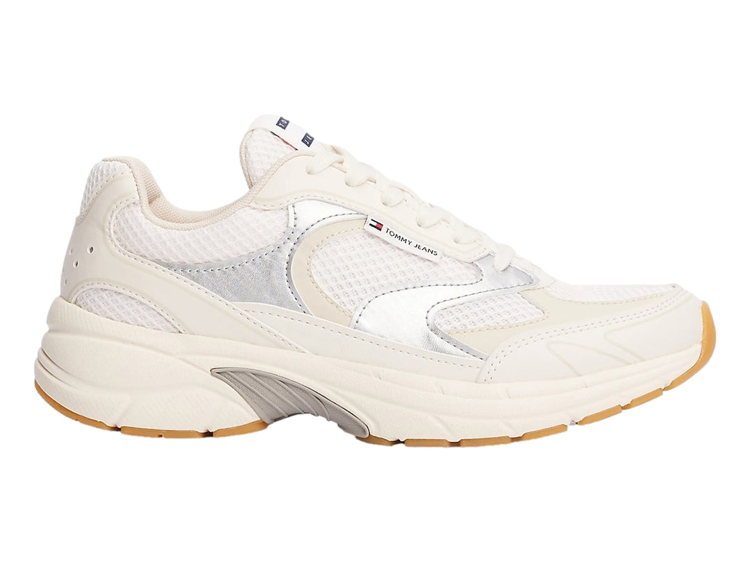 Tenis deportivos Tommy Hilfiger color blanco hueso con detalles plateados y suela de goma marrón.