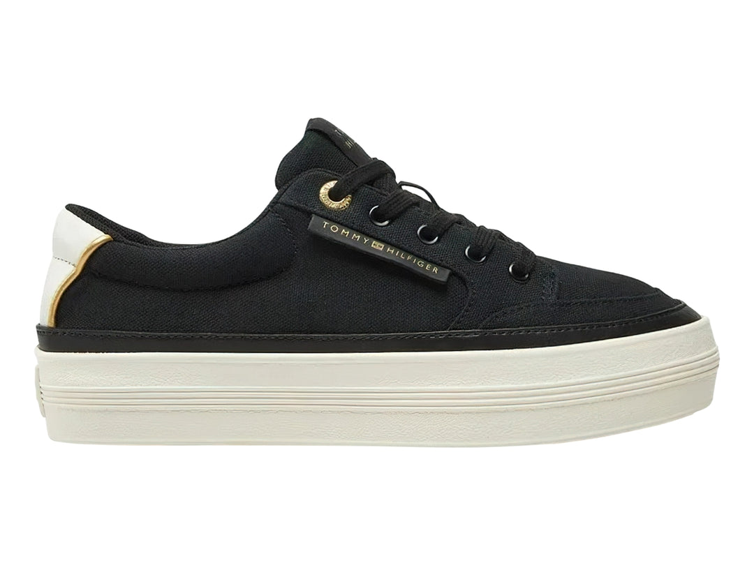 Tenis Tommy Hilfiger de tela color negro con suela blanca gruesa y detalles dorados.