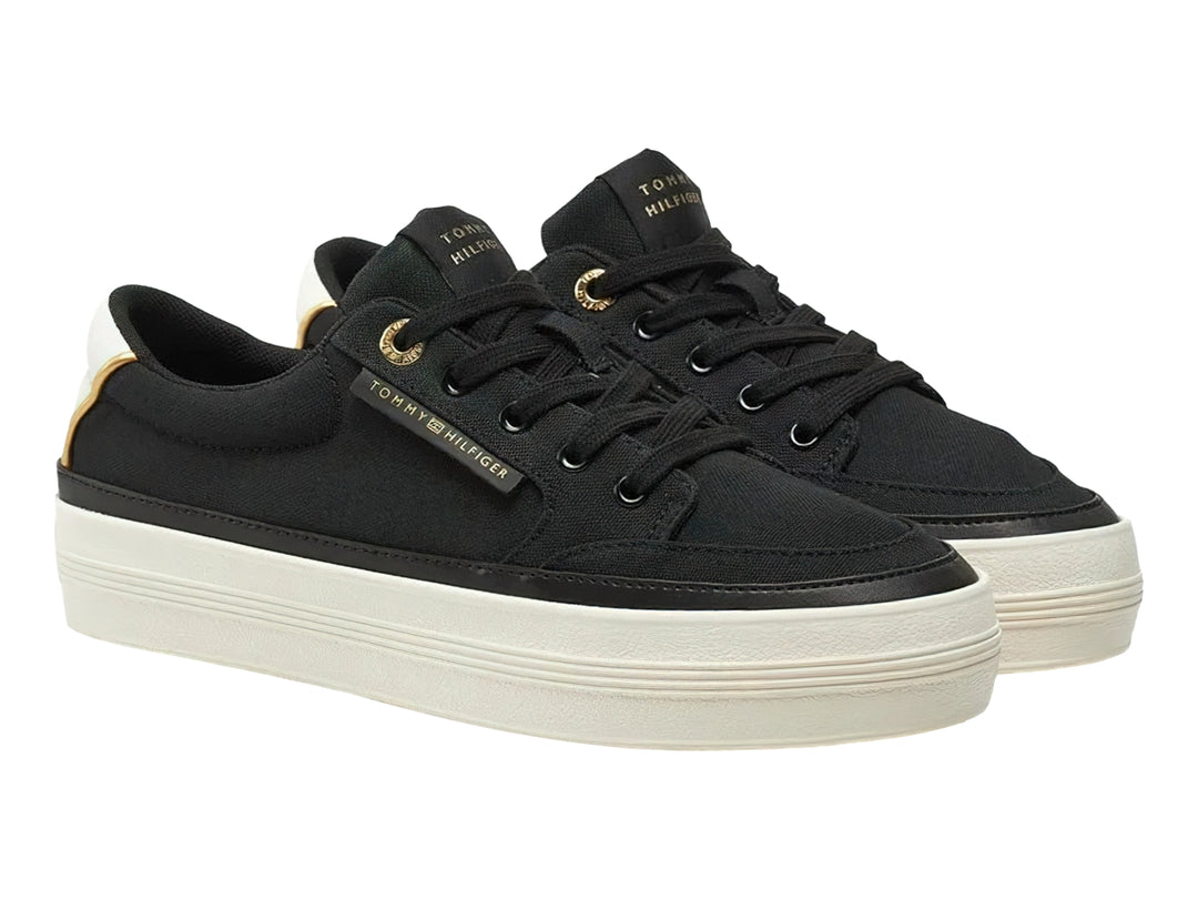 Tenis Tommy Hilfiger de tela color negro con suela blanca gruesa y detalles dorados.