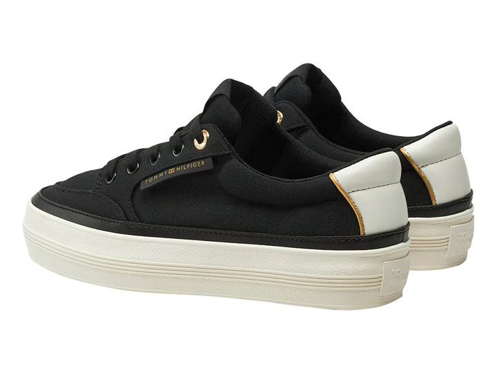 Tenis Tommy Hilfiger de tela color negro con suela blanca gruesa y detalles dorados.