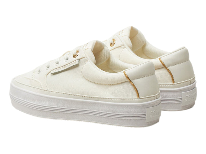 Tenis Tommy Hilfiger color ecru con suela de plataforma blanca y detalles dorados.