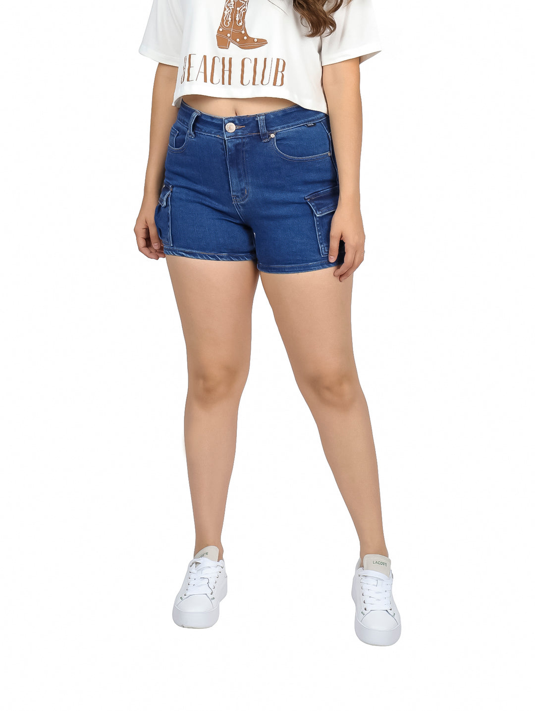 Mujer vistiendo shorts de mezclilla azul con bolsillos laterales tipo cargo y camiseta blanca.