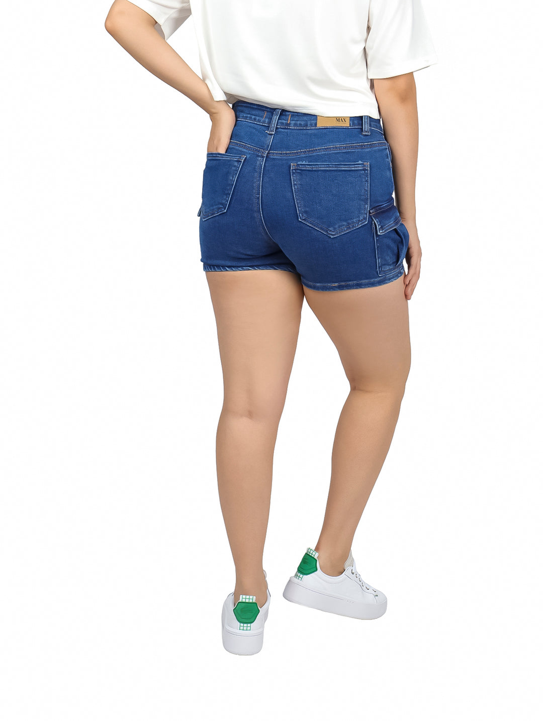 Mujer vistiendo shorts de mezclilla azul con bolsillos laterales tipo cargo y camiseta blanca.