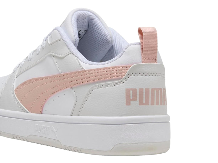 Tenis PUMA Rebound V6 Low color blanco con franja rosa lateral y suela blanca.