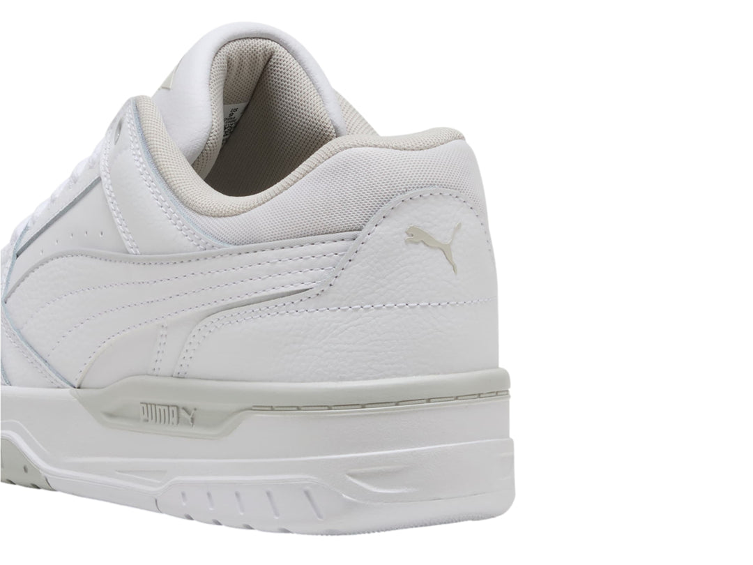 Tenis PUMA Rebound Retro en color blanco con detalles en gris claro, diseño deportivo de corte bajo.