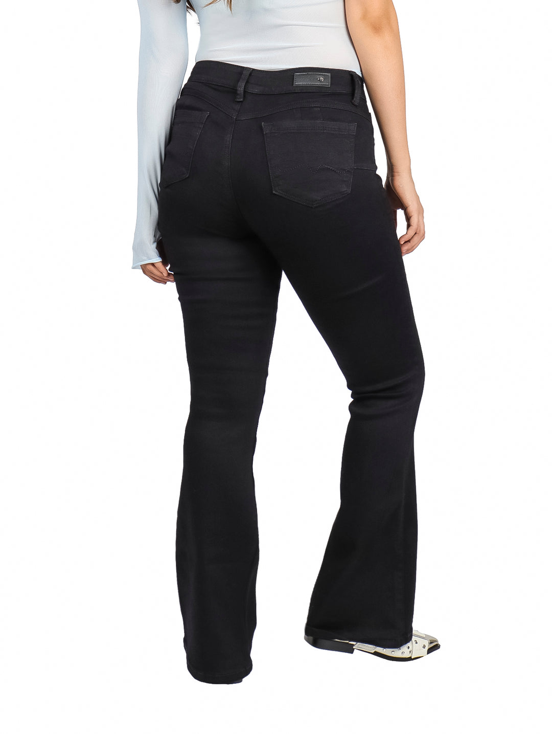 Mujer vistiendo jeans negros de corte campana marca Dolce and Amaro.