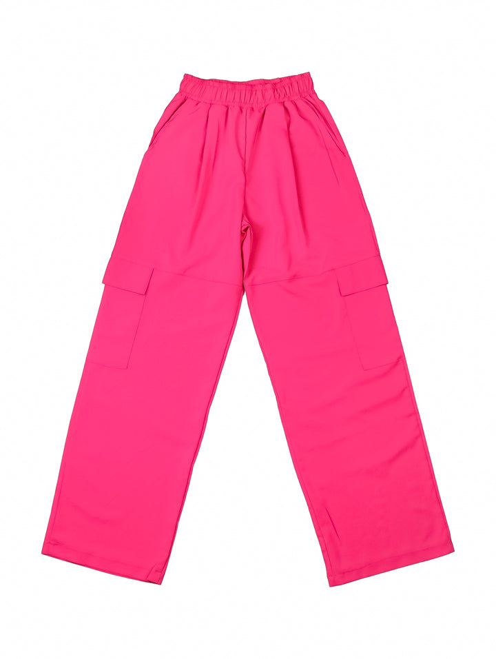 Mujer vistiendo pantalones color fucsia de corte recto con cintura elástica y bolsillos.